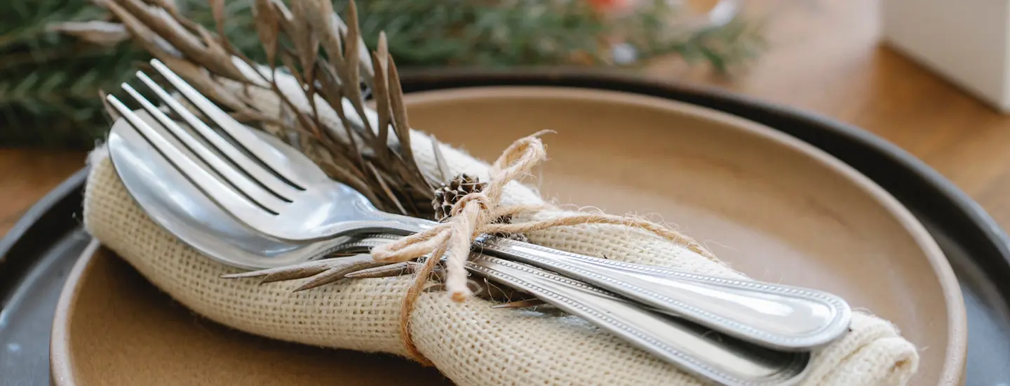 Borddækning Med To Tallerkner Med Stofserviet Og Bestik Og Gran Bundet Med Sejlgarn